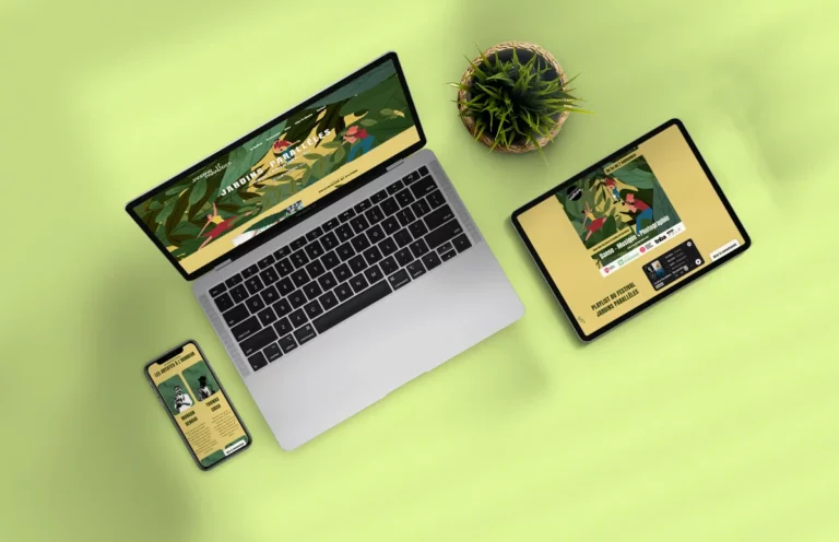Vue en plongée d'un ordinateur portable, smartphone et tablette affichant un site web responsive sur fond vert clair